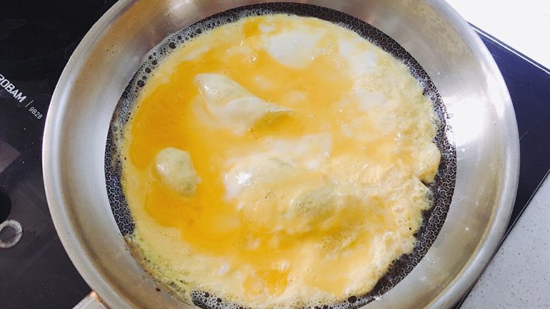 咖喱蛋包饭,平底锅倒入适量油，倒入鸡蛋液，摊成鸡蛋饼；