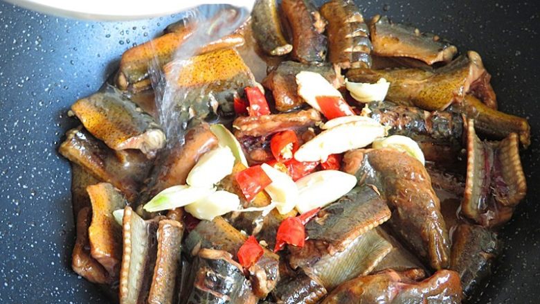 红烧鳝鱼,将炸过的姜、蒜、红辣椒倒入锅内，加一碗水盖上锅盖烧5分钟