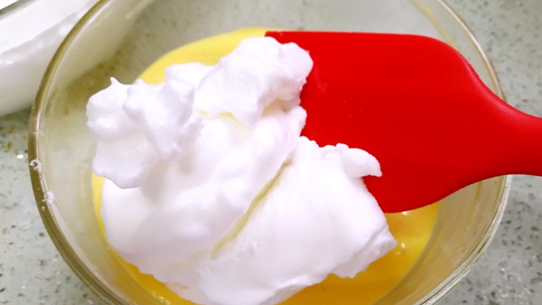 酸奶戚风蛋糕,烤箱预热140度。从冰箱取出蛋白，舀1/3的蛋白与蛋黄糊翻拌均匀。