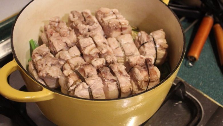 东坡肉,将五花肉块皮面朝下放入锅中。