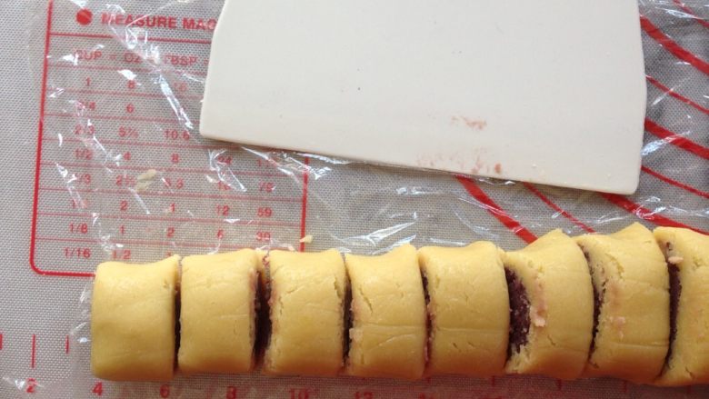 紫薯一口酥,卷起来揉搓几下，使面片和馅料更贴合，然后切成2厘米宽的长度