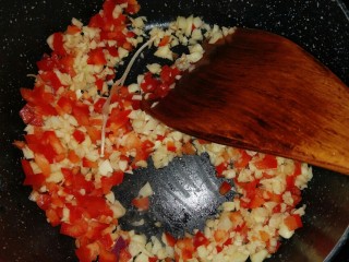 蒜蓉金针菇烤花蛤,第五步，炒配料。加油，把彩椒和蒜末炒一下。（我切的比较大，切的越碎越好，油可以多一点，我为了健康放的比较少）