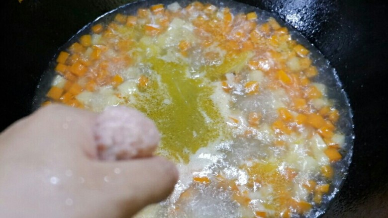 三丁肉丸粉丝汤,然后就可以挤肉丸进去锅里了。肉馅抓手里，用虎口位置挤出