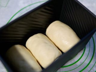 蜜豆吐司,卷好的面包卷放入黑金刚的模具里面