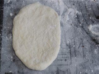 罗宋红豆甜面包,取一份醒好的面团，擀成椭圆形并拍除周边气泡