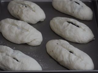 罗宋红豆甜面包,将做好的面包胚放在烤盘上进行二发，二发好后，扫一层蛋液后在中间割一道口子