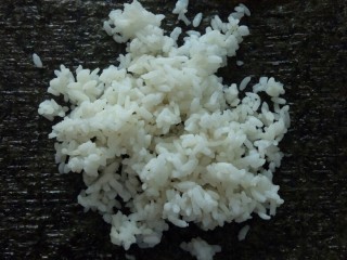 培根寿司卷,幼嫩紫菜铺菜板上，放上米饭。