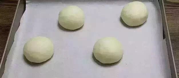 冰火菠萝,20分钟后，面团再次滚圆整形，放在烤盘上。每个之间都要留出足够的空隙。放入发酵箱或者烤箱内进行二次发酵。约50分钟