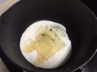 抹茶酸奶双色吐司,一半酸奶倒入奶锅加热，放入软化的吉利丁片至融化。