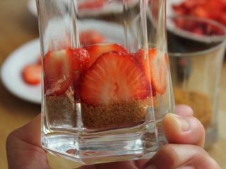 草莓冻芝士,12.组装草莓芝士慕斯杯，在已有饼干碎垫底的杯中放一圈草莓片。