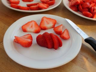 草莓冻芝士,3. 草莓去蒂，一切为四，中间两片做为装饰；边角料一部分打果汁；一部分做为果粒放在草莓芝士慕斯馅中。
