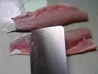酸菜鱼,鱼肉块洗干净血污，下面放一块洗碗布，刀斜大概40度左右，从尾部开始开片鱼，方向是刀刃朝向尾部，开成鱼片