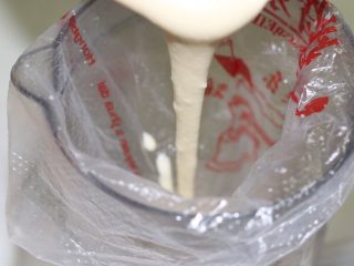 奶香四溢的酸奶厚松饼,在深的容器里套上一个裱花袋，没有可以用保鲜袋代替，倒进面糊