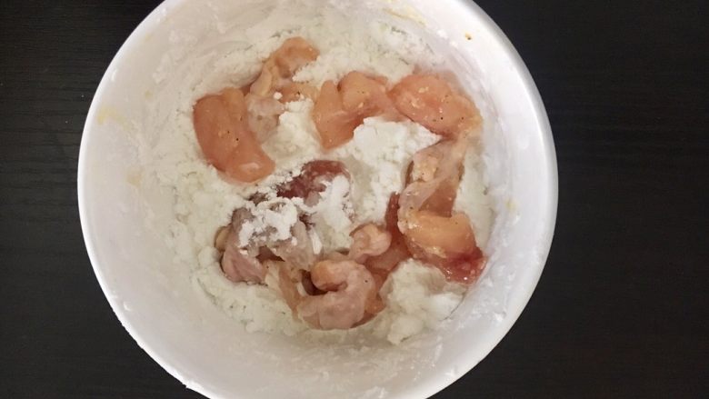 自制鸡米花,将腌制完成的鸡肉依次放入淀粉碗里，均匀地裹上一层淡粉。
