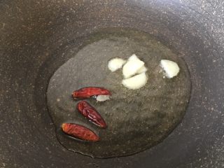 手撕包菜,辣椒和大蒜头放油锅中炒出香味
