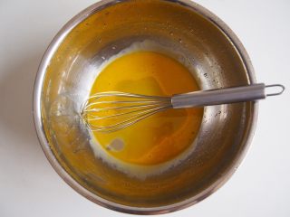 咖啡山药蛋糕卷,
蛋黄和蛋清分离后，将蛋黄中加入玉米油，搅拌均匀，然后加入牛奶，同样搅拌均匀