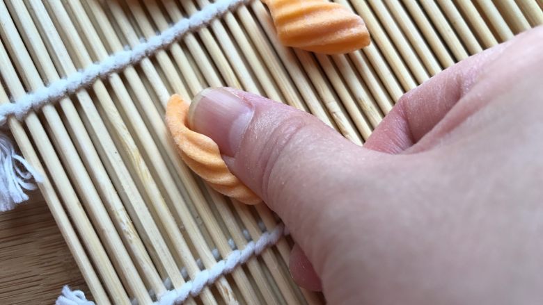 多彩麻食,把小块面团放在寿司帘上，用大拇指摁压，往前搓至卷起即可