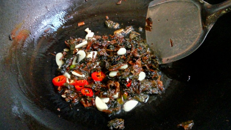 豆豉酸菜炒苦瓜,油烧热后，先把蒜子，浏阳豆豉，干酸菜，红椒依次下锅稍微煸炒。