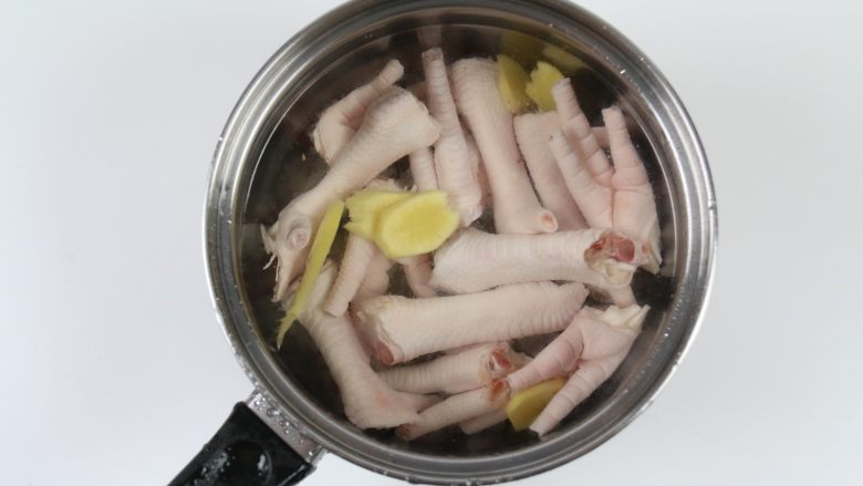 排骨鸡脚木瓜汤,锅里加入适量的水，放入鸡脚，加入几片姜，煮开后继续煮一分钟即可关火，把鸡脚捞出来清洗去血沫。