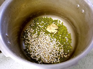 海带绿豆薏米糖水,把绿豆、薏米、生姜倒入高压锅里。