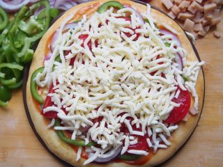 番茄鸡肉肠披萨,最后根据自己的喜好铺上一层马苏里拉奶酪，饼胚外缘用刷子刷一层橄榄油