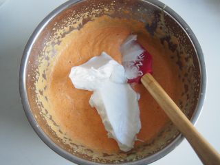 胡萝卜小蛋糕,将蛋白取三分之一加入蛋黄糊中，切拌均匀。