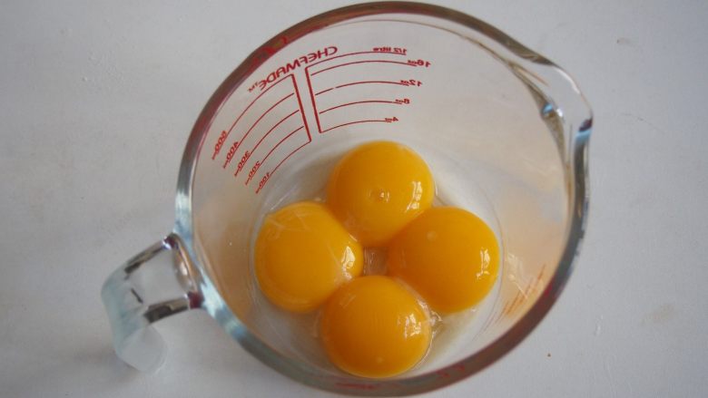 戚风苹果卷,蛋白和蛋黄分离，蛋黄放入玻璃碗中搅打均匀。
