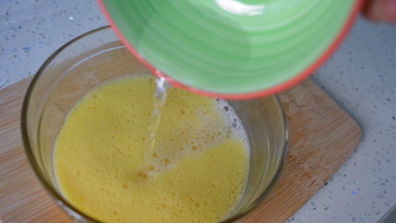 秋葵蒸蛋羹,将温水倒入蛋液稍微搅拌。记住这里必须要用温水哦！