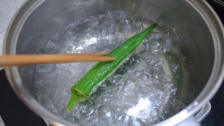 秋葵蒸蛋羹,水开后将秋葵整个放入沸水里焯水一分钟。焯水的时候秋葵是浮在水面的，要用筷子将秋葵翻滚一下。