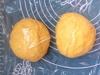 中种南瓜吐司面包,取出面团分割成两等份，排气滚圆，盖保鲜膜静置一刻钟。
