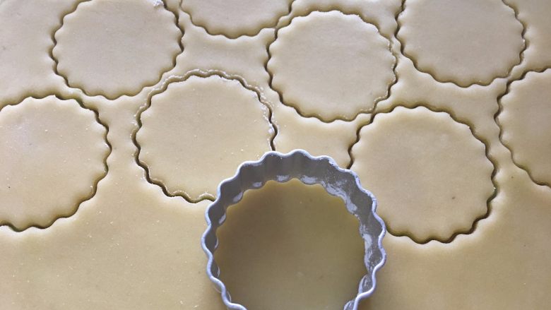 幸福奶酥饼干,凝固的面团擀成薄片0.3cm厚度，用圆形花边饼干模具压出花形