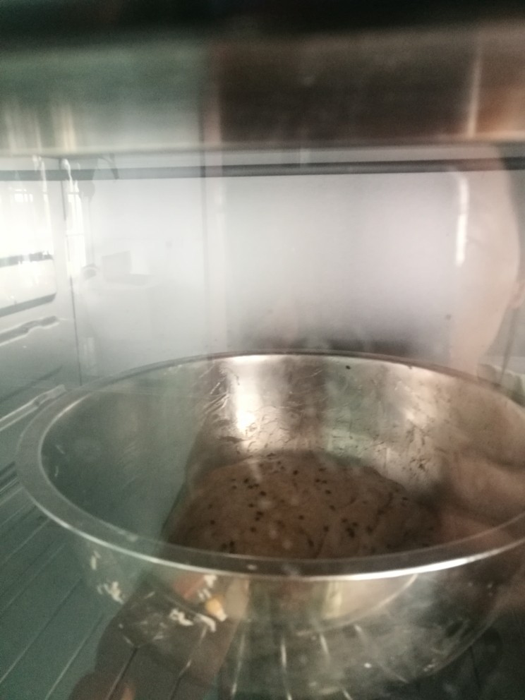 黑芝麻黑麦黄油吐司,混合搓匀后的面团放入烤箱进行发酵45分钟