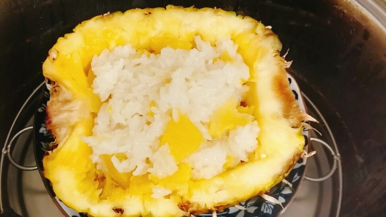 菠萝糯米饭,将拌好的菠萝饭放在准备好的菠萝里，上锅蒸十分钟。