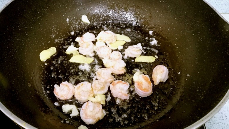 三珍炒虾球,锅里再倒一点油，爆香姜蒜，倒入虾仁，翻炒至成球状。
