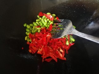 牛筋炒毛豆,少量盐翻炒均匀略炒入味后倒入红椒小米椒，不想辣的可以减掉小米椒。
