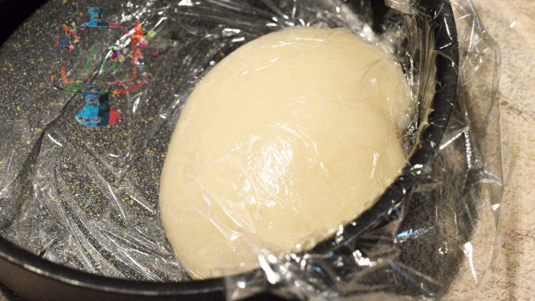 蛋糕界的大福——玫瑰白玉卷, 用保鲜膜贴面保存降温放凉。然后转入冰箱冷藏1小时。贴面保存这个手法在甜品制作中用的非常多。大家应该在很多款甜点的制作手法中都有看到过