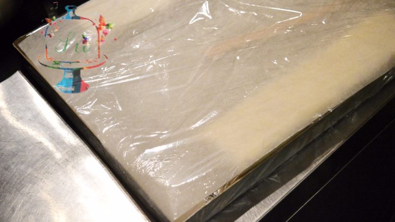 蛋糕界的大福——玫瑰白玉卷,加盖一层油纸后，保鲜膜密封起来放入冰箱冷藏1晚
