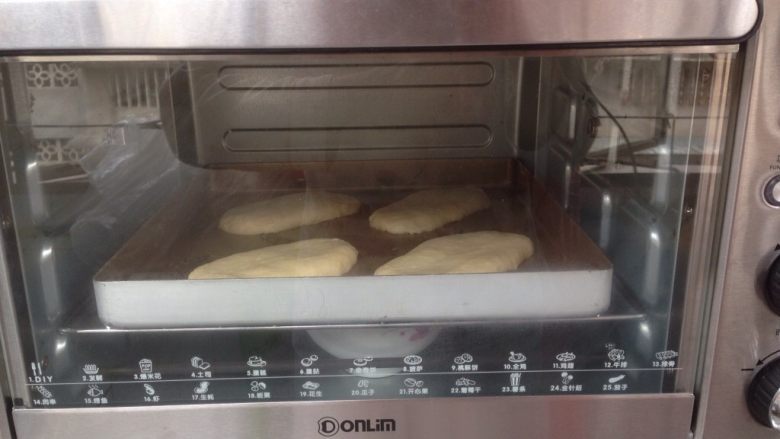 香葱培根沙拉面包,放在烤盘上，将做好的面包胚放入到烤箱里，选择发酵功能40分钟，烤箱内放置一碗热水，使烤箱内保持一定的湿度