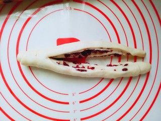 蔓越莓面包,卷好的面团从中间用锋利的刀切开。顶部不要切你哦，如图。