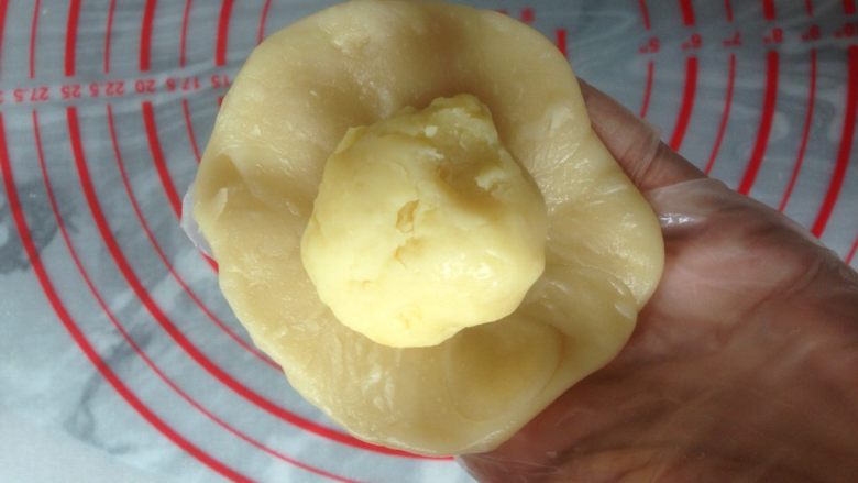 植物油版绿豆酥饼,擀成中间厚四周薄的圆形面皮，中间放入绿豆馅