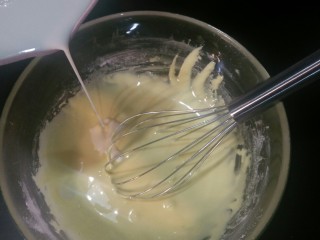 酥皮泡芙,牛奶晾凉，慢慢倒入蛋黄和面糊混合物中，一边倒一边搅拌，直到完全搅拌均匀。