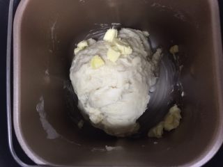 蔓越莓椰蓉千层吐司,和面10分钟左右后，加入提前室温融化的黄油，切成小块。继续和面