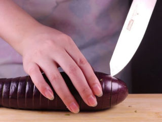 教你一个茄子的新吃法，又香又好吃一看就会,接着用刀子将茄子切成连刀的厚片状。（记得别切断了哦）
