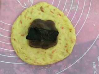 巧克力红豆沙胡萝卜软欧,用手或者擀面杖擀压排气成圆形状后放上红豆沙和黑巧克力