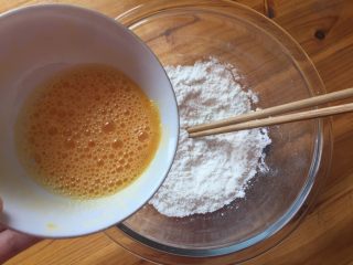 简单易做的小麻花,将混合后的蛋液倒入面粉中搅拌成絮状后，揉成面团。