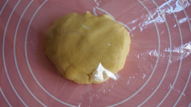 童趣翻糖饼干,在面板上铺上一层保鲜膜，放上面团，上面再覆盖一层保鲜膜