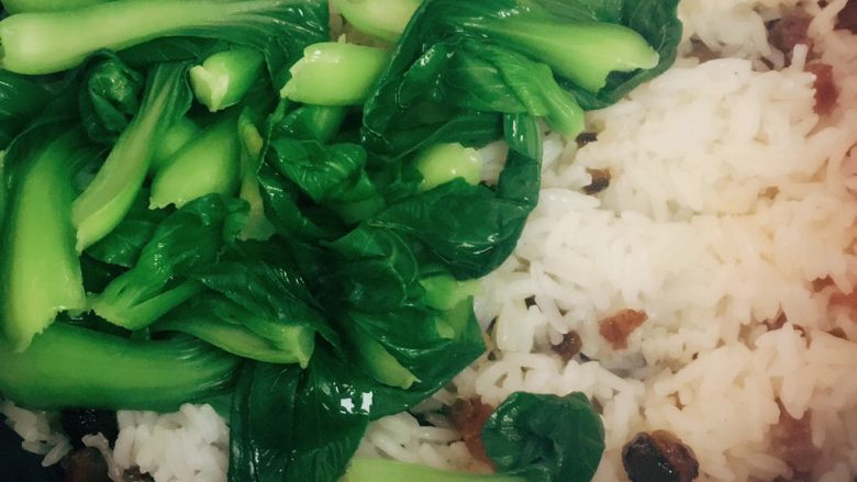 广式腊味焖饭,饭煮熟后，将青菜下入米饭中，搅拌均匀