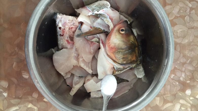 美味火锅鱼,放入盐6勺豁匀，用手不停的拌鱼，直到鱼片发粘时才能停止。因鱼头块大，最好单独拿出来腌制。注意：盐要放多点，熟后再放盐是无法入味的，所以宁多勿少。