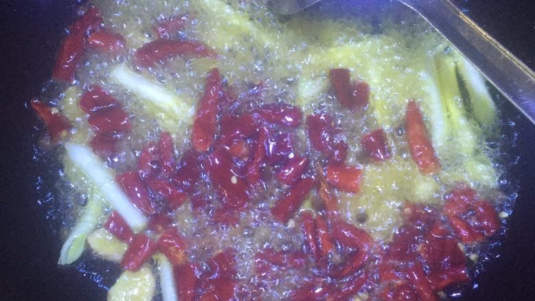 美味火锅鱼,紧接着倒入辣椒段和花椒，并把火关小一点，炒制半分钟。