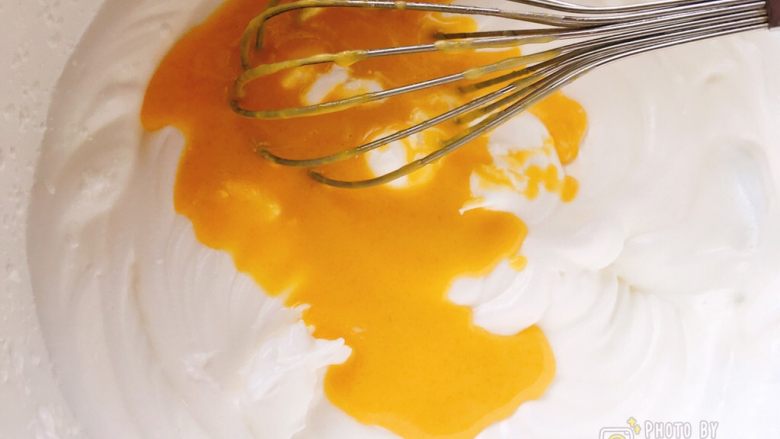 像海绵一样柔软的南瓜蛋糕,分次倒入蛋黄糊，翻拌均匀再倒入剩余的。